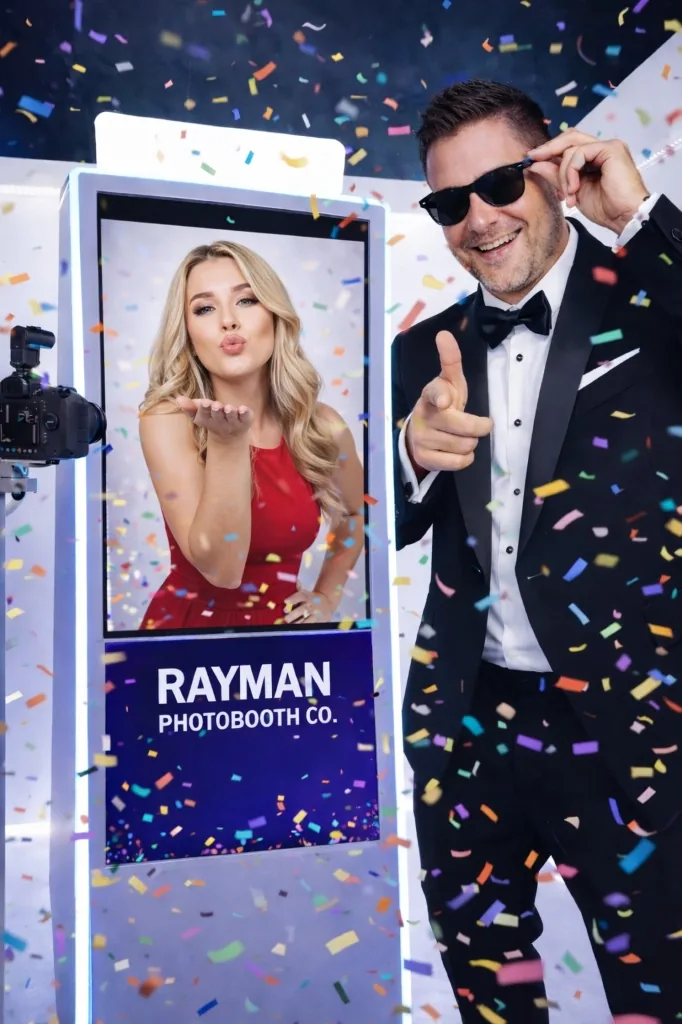 Rayman Photobooth Co. digital photobooth with confetti and a guest posing in a tuxedo